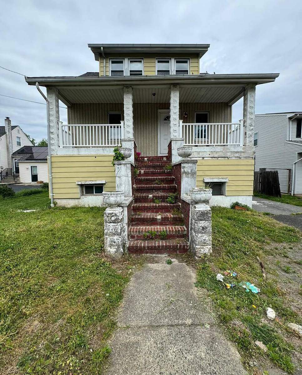 Before — original crumbling front stairs and yellow siding